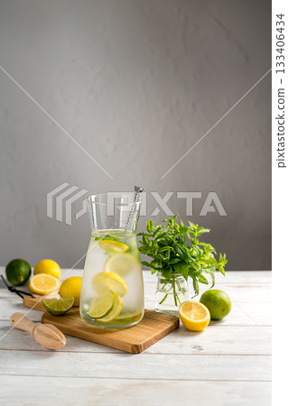 A glass jug with lemonade with lemons, limes and fresh mint, summer drink, copy space A glass jug with lemonade with lemons, limes and fresh mint, summer drink, copy space 133406434