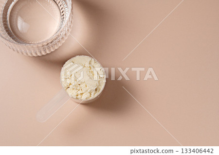Protein powder. Vanilla flavour of protein powder in a scoop, closeup. 133406442