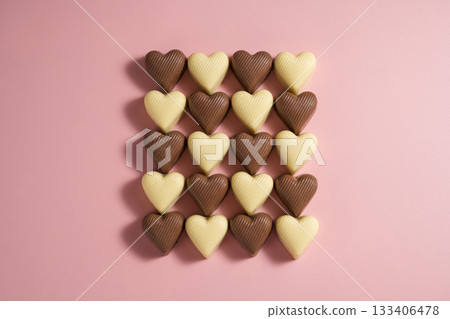 Heart-shaped chocolate pieces over pink background, abstract food love background Heart-shaped chocolate pieces over pink background, abstract food love background 133406478