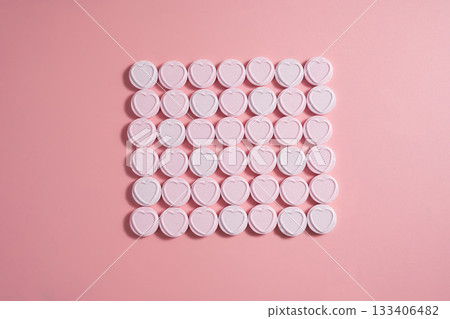 Heart-shaped candies over pink background, abstract food love background Heart-shaped candies over pink background, abstract food love background 133406482