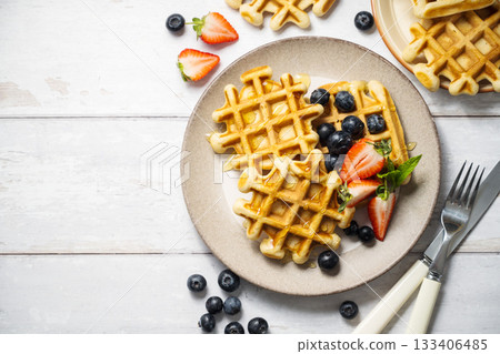 Belgian homemade waffles with strawberries, blueberries and honey, copy space 133406485