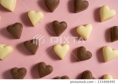 Heart-shaped chocolate pieces over pink background, abstract food love background Heart-shaped chocolate pieces over pink background, abstract food love background 133406495