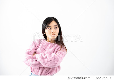 Angry young woman with arms crossed in front of a white background 133406697