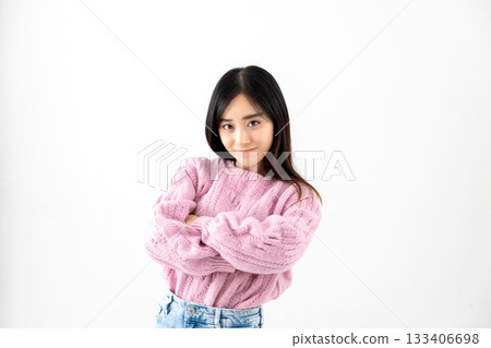 Angry young woman with arms crossed in front of a white background 133406698