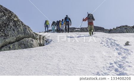 Hikers enjoying a snowy trek in Leirdalen, Jotunheimen National Park on a bright day 133408208
