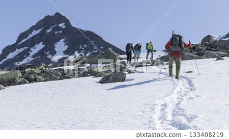 Explore the snowy landscape of Leirvassbu in Leirdalen Jotunheimen National Park on a clear day with adventurers trekking through the snow 133408219