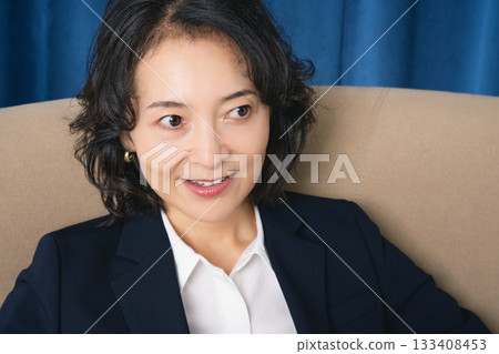 坐在大椅子上的中年女商人 133408453