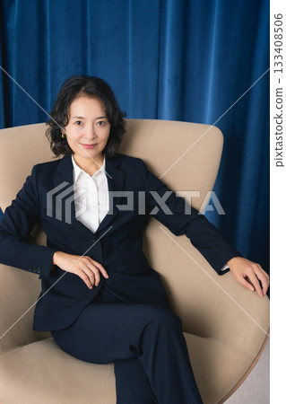 坐在大椅子上的中年女商人 坐在大椅子上的中年女商人 133408506