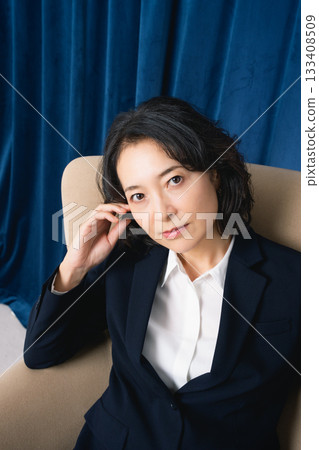 Middle-aged businesswoman sitting on a large chair 133408509