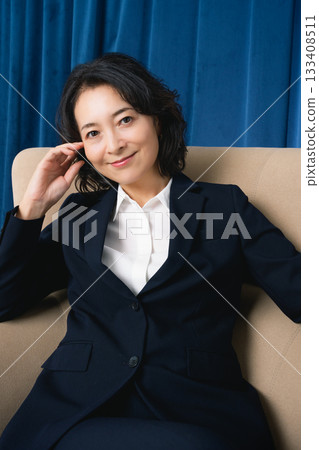 坐在大椅子上的中年女商人 坐在大椅子上的中年女商人 133408511