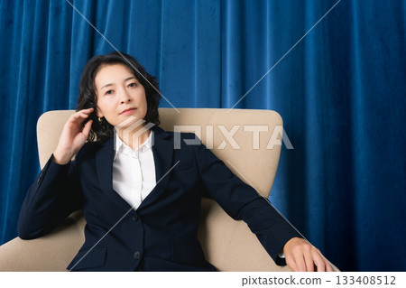 坐在大椅子上的中年女商人 坐在大椅子上的中年女商人 133408512