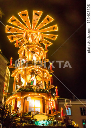 Traditional spinning Christmas pyramid lit up at night, at Christmas market in Basel, Switzerland Traditional spinning Christmas pyramid lit up at night, at Christmas market in Basel, Switzerland 133408808
