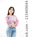 Young woman standing with a laptop against white background 133409044