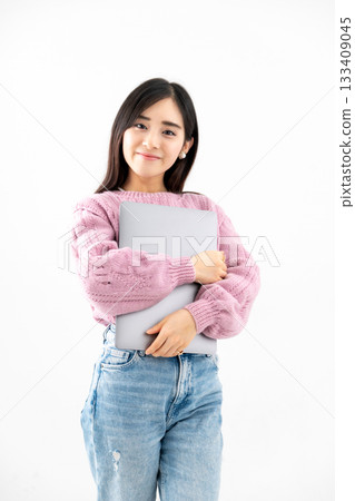 Young woman standing with a laptop against white background Young woman standing with a laptop against white background 133409045