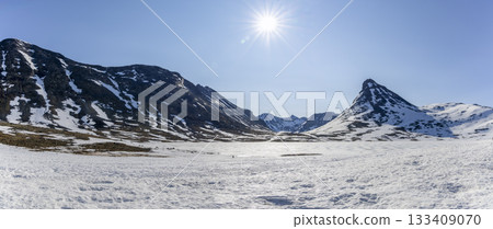 Snowy landscape in Leirdalen showcasing stunning peaks in Jotunheimen National Park on a clear day in spring Snowy landscape in Leirdalen showcasing stunning peaks in Jotunheimen National Park on a clear day in spring 133409070