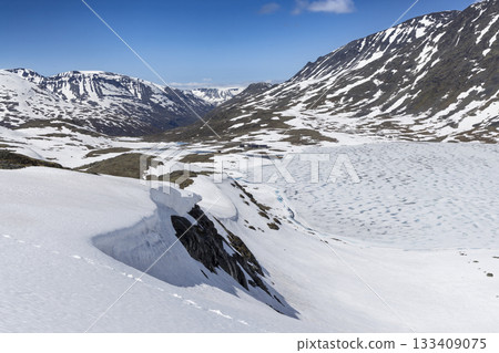 Snowy landscape in Leirdalen near Leirvassbu reveals stunning mountains and frozen lake in Jotunheimen National Park 133409075