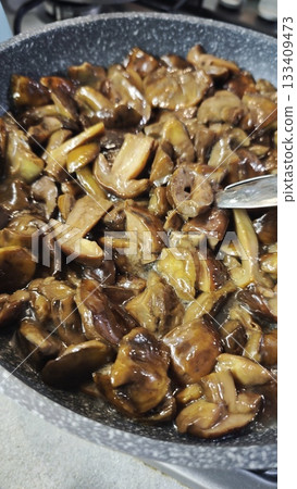 Cooked mushrooms in a pan glistening with sauce and ready to serve Cooked mushrooms in a pan glistening with sauce and ready to serve 133409473