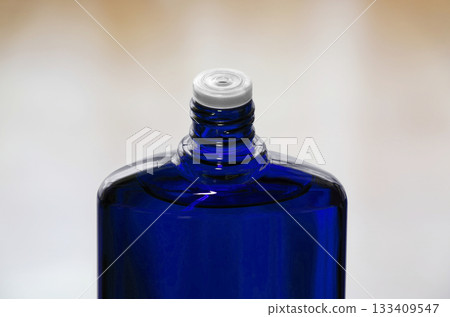 A blue translucent bottle of hair growth product with the screw cap open A blue translucent bottle of hair growth product with the screw cap open 133409547