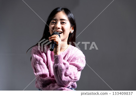 年輕女子拿著麥克風說話 年輕女子拿著麥克風說話 133409837