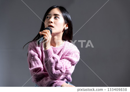 年輕女子拿著麥克風說話 年輕女子拿著麥克風說話 133409838