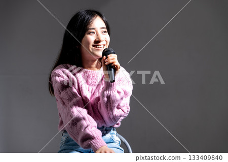 Young woman speaking with a microphone Young woman speaking with a microphone 133409840