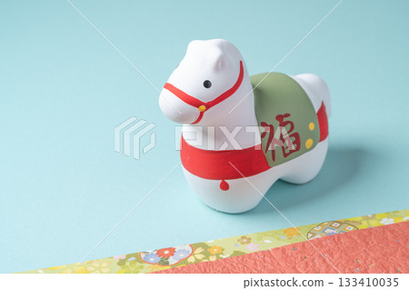 一幅構圖簡潔的畫作，畫面中一匹馬擺飾代表馬年，放置在淺藍色背景上。 133410035