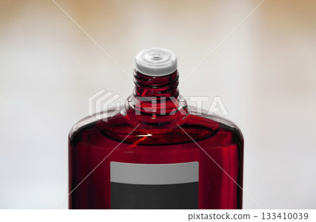 一瓶紅色半透明的生髮產品,瓶蓋是打開的。 一瓶紅色半透明的生髮產品,瓶蓋是打開的。 133410039
