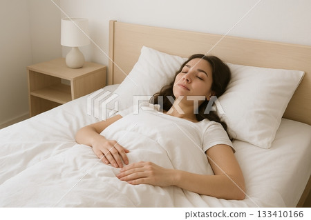 Young hispanic woman peacefully sleeping in a cozy bedroom with white bedding during daytime nap. concept of relaxation, restful sleep, comfort. 133410166