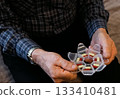 Elderly person organizing weekly medication in a pillbox at home during afternoon 133410481