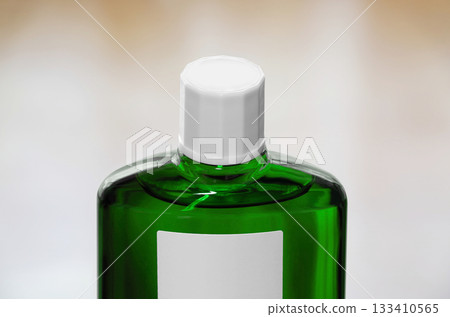 A green translucent bottle of hair growth product with a screw cap A green translucent bottle of hair growth product with a screw cap 133410565