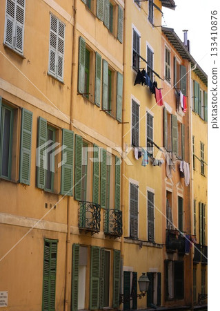 Beautiful yellow house with clothes on the windows Beautiful yellow house with clothes on the windows 133410876