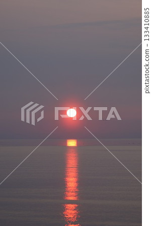 Beautiful sunset with sun road on the sea. Vertical photography of red sunset. 133410885