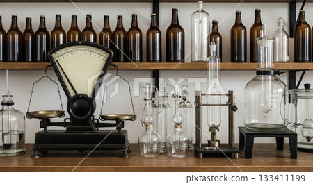Vintage scale and various laboratory glassware on wooden shelves, evoking chemistry, pharmacy, or old science. Historical equipment for scientific research. Vintage scale and various laboratory glassware on wooden shelves, evoking chemistry, pharmacy, or old science. Historical equipment for scientific research. 133411199