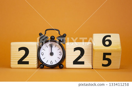 2026 New Year symbol. Businessman turns wooden cube and changes Year 2025 to 2026. Beautiful orange background with Alarm clock. Copy space. Business and 2026 happy new year concept 2026 New Year symbol. Businessman turns wooden cube and changes Year 2025 to 2026. Beautiful orange background with Alarm clock. Copy space. Business and 2026 happy new year concept 133411258