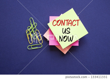 Contact us now symbol. Sticky notes with words Contact us now. Beautiful deep blue background. Business and Contact us now concept. Copy space. 133411331