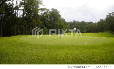 Golfers are putting golf in the evening golf course golf backglound. Golfers are putting golf in the evening golf course golf backglound. 133411392