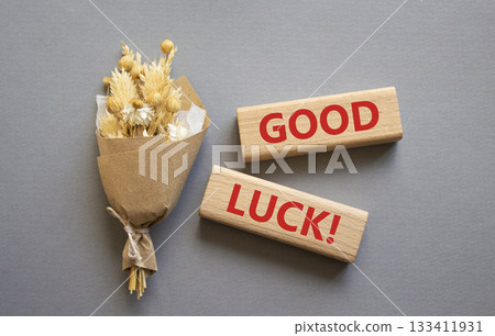 Good luck symbol. Wooden blocks with words Good luck. Beautiful grey background with bouquet of flowers. Business and Good luck concept. Copy space. Good luck symbol. Wooden blocks with words Good luck. Beautiful grey background with bouquet of flowers. Business and Good luck concept. Copy space. 133411931