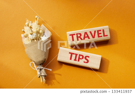 Travel tips symbol. Wooden blocks with words Travel tips. Beautiful orange background. Business and Travel tips concept. Copy space. 133411937