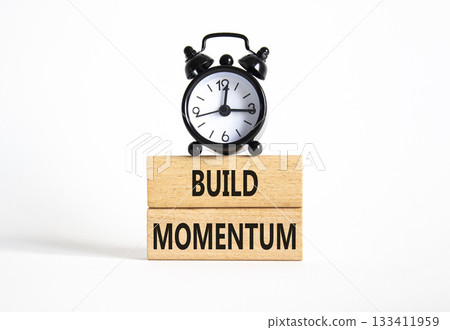 Build momentum symbol. Wooden blocks with words Build momentum. Beautiful white background with alarm clock. Business and Build momentum concept. Copy space. Build momentum symbol. Wooden blocks with words Build momentum. Beautiful white background with alarm clock. Business and Build momentum concept. Copy space. 133411959