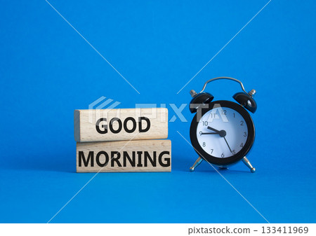 Good Morning symbol. Concept word Good Morning on wooden blocks. Beautiful blue background with alarm clock. Business and Good Morning concept. Copy space Good Morning symbol. Concept word Good Morning on wooden blocks. Beautiful blue background with alarm clock. Business and Good Morning concept. Copy space 133411969