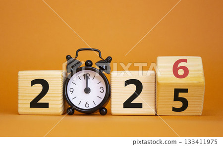 2026 New Year symbol. Businessman turns wooden cube and changes Year 2025 to 2026. Beautiful orange background with Alarm clock. Copy space. Business and 2026 happy new year concept 2026 New Year symbol. Businessman turns wooden cube and changes Year 2025 to 2026. Beautiful orange background with Alarm clock. Copy space. Business and 2026 happy new year concept 133411975