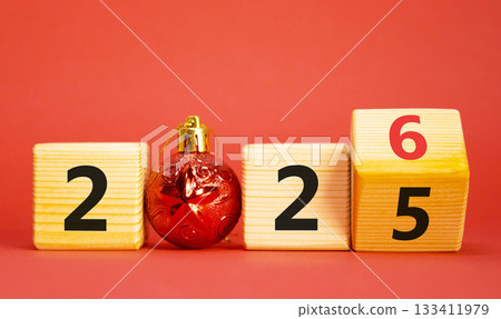 2026 New Year symbol. Businessman turns wooden cube and changes Year 2025 to 2026. Beautiful red background with christmas ball. Copy space. Business and 2026 happy new year concept 2026 New Year symbol. Businessman turns wooden cube and changes Year 2025 to 2026. Beautiful red background with christmas ball. Copy space. Business and 2026 happy new year concept 133411979