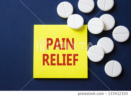 Pain Relief symbol. Concept word Pain Relief on yellow note. Beautiful deep blue background with pills. Medicine and Pain Relief concept. Copy space Pain Relief symbol. Concept word Pain Relief on yellow note. Beautiful deep blue background with pills. Medicine and Pain Relief concept. Copy space 133412103