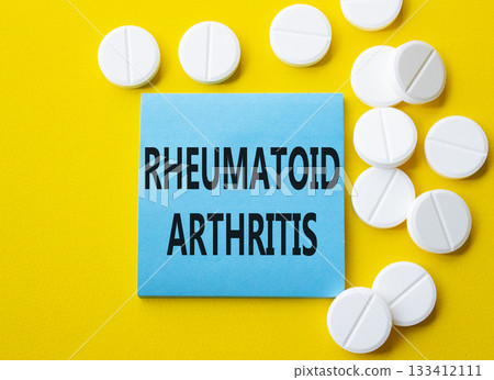 Rheumatoid Arthritis symbol. Concept word Rheumatoid Arthritis on blue note. Beautiful yellow background with pills. Medicine and Rheumatoid Arthritis concept. Copy space 133412111