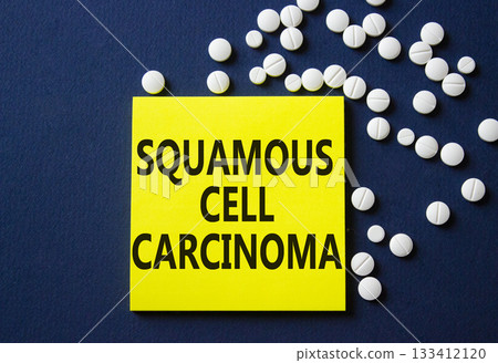 Squamous Cell Carcinoma symbol. Concept words Squamous Cell Carcinoma on yellow note. Beautiful deep blue background with pills. Healthcare and Squamous Cell Carcinoma concept. Copy space. 133412120