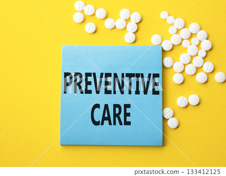 Preventive Care symbol. Concept word Preventive Care on blue note. Beautiful yellow background with pills. Medicine and Preventive Care concept. Copy space Preventive Care symbol. Concept word Preventive Care on blue note. Beautiful yellow background with pills. Medicine and Preventive Care concept. Copy space 133412125