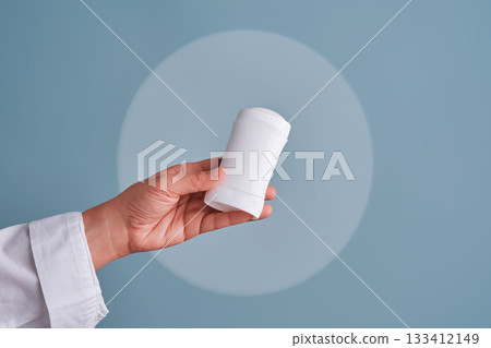 Hand holding white blank deodorant stick 133412149