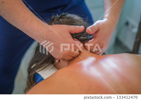 A professional therapist provides a soothing neck massage with oil, focusing on relaxation and lymphatic drainage for wellness. 133412470