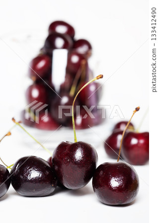 Sweet ripe cherries in glass bowl around white background Sweet ripe cherries in glass bowl around white background 133412490