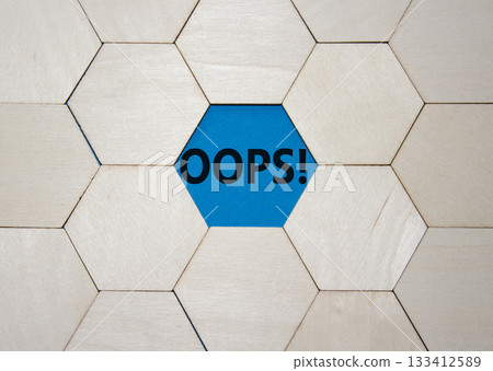 Oops symbol. Concept word Oops on wooden comb puzzle. Beautiful blue background. Business and Oops concept. Copy space. Oops symbol. Concept word Oops on wooden comb puzzle. Beautiful blue background. Business and Oops concept. Copy space. 133412589
